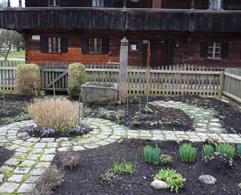 winterlicher Küchengarten mit Brunnen vor dem historischen Blaahaus in Kieferfelden